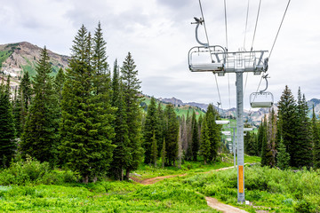 Albion Basin, Utah summer with ski lift chairs on cables and cloudy sky in rocky Wasatch mountains...