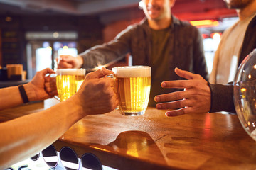 Crop bartender giving beer to men