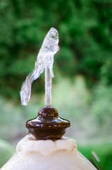 Old marble and metal water public fontaine in a park. Close-up photo of water drops