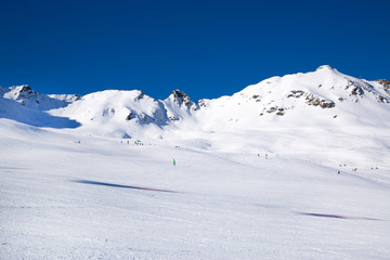 Fototapeta na wymiar Wide ski slope in Soelden, Tirol, Austria. Alpine mountiines, covered with snow. Bright sunny day with blue sky. 
