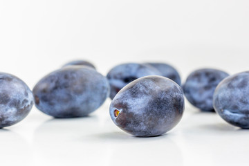 Ripe plums on white table. Close up