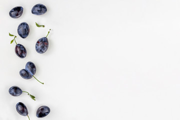 Plum pattern on white. Fruit group with copy space. Top view, flat lay.