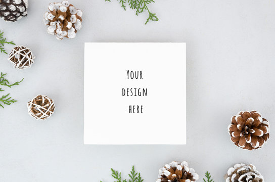 Christmas border frame design with pine cones and fir branches. Blank paper mockup for you text over white background