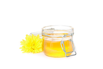 Chrysanthemum and glass jar with honey isolated on white background