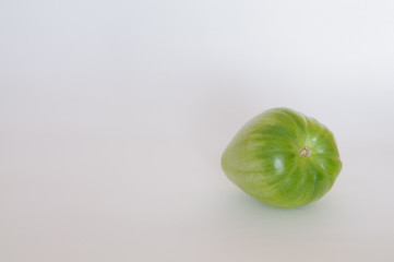 green tomato on a white background