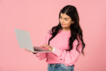 Naklejka premium beautiful girl using laptop, isolated on pink