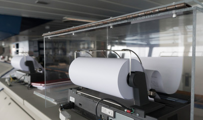 Navigational bridge on a cruise ship. Messages are coming on a paper nautical fax. Very important for officers on watch. Newest equipment on a vessel.