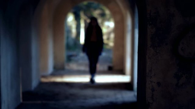 Violence against women. aggressive man attacking woman in a dark tunnel