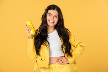 beautiful brunette girl holding soda can, isolated on yellow