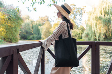 Woman with black blank bag outdoors in park. Place for Empty space. Copy space. Eco friendly.