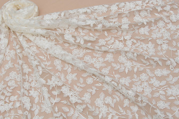 Texture lace fabric. lace on white background studio. thin fabric made of yarn or thread. a background image of ivory-colored lace cloth. White lace on beige background.