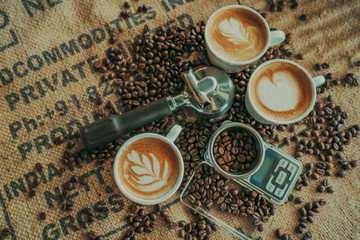 Coffee spoon, modern coffee scale,cup of coffee and coffee grinder on old table