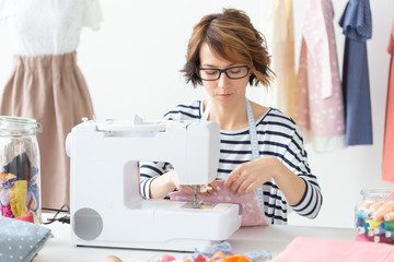 clothing designer, seamstress, people concept - clothing designer working in her studio