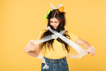 emotional young woman with rubbish in hair isolated on yellow
