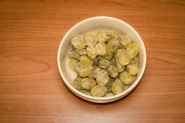 Grapes in a plate on wood
