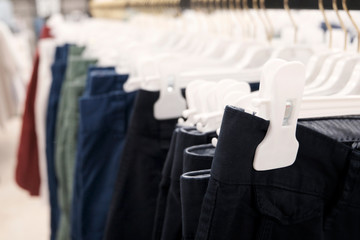 Pants, shorts on hangers in the clothing store and textiles made of natural materials. The concept of seasonal sale