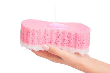 Shower gel is poured on the sponge body in a female hand