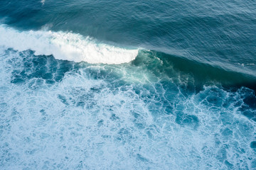 Breaking blue wave in bali, indonesia