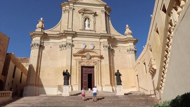 A Couple Walks Up The Main Church Steps Of The Citadel Of Victoria.