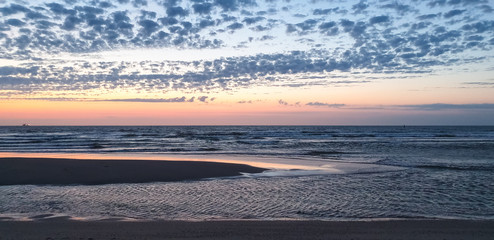 Obraz premium Beautiful panorama of sandbanks at North Sea coast during colorful sunset