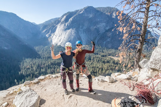 Two women pose victoriously after completing their climbing objective