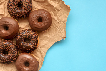 Doughnuts with chocolate glazing on blue background, top view