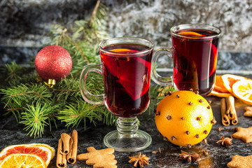 Christmas mulled wine with ginger biscuits orange cinnamon clove anise and fir tree on the dark table