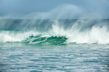 Fototapeta na wymiar Rolling turquoise surf breaks at Fistral beach in Cornwall