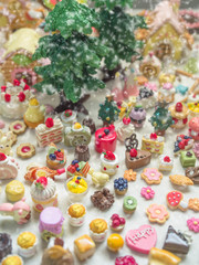 Fototapeta na wymiar Merry Chrismas with a lot of miniature toys in snow. Sweet party, dessert table toy concept.