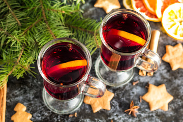 Christmas mulled wine with ginger biscuits orange cinnamon clove anise and fir tree on the dark table