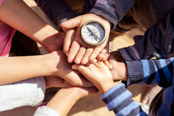 children holding a compass pointing north