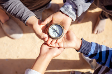 children holding a compass pointing north