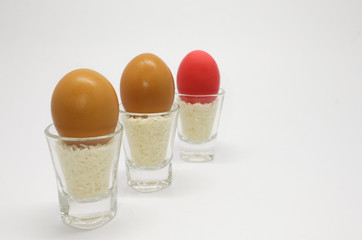3 eggs in the glass, two normal egg and one red egg.