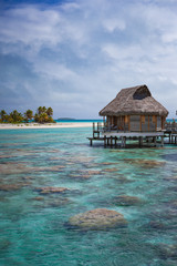Vertical of overwater bungalow luxury resort in calm tropical lagoon paradise