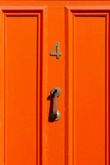 House number 4 on a bright orange door