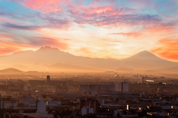 Mexico City at dawn and volcanoes silhoutte
