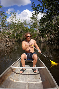 Handsome Young Man Paddling Canoe Through Florida Everglades Backwaters