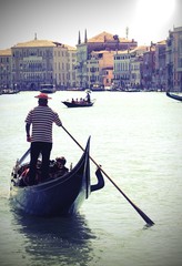 Fototapeta na wymiar Gondolier in Grand Canal in Venice with old toned effect