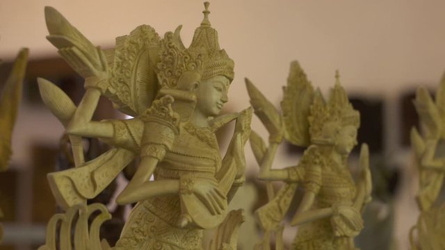 Rack focus between small statues of four armed deities