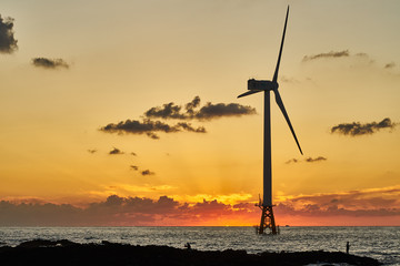 Sunset of western Jeju island with offshore wind turbine