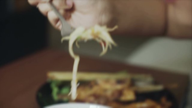 Young Asian Woman is eating green pappaya salad som tam closeup