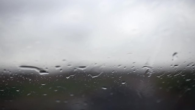 Raindrops on the car glass. Blurry silhouette. Wet car window. Close up rain drop
