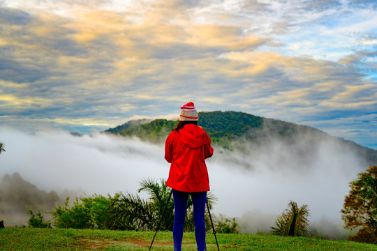 traveller woman enjoy taking photo at sunrise on the peak of mountain