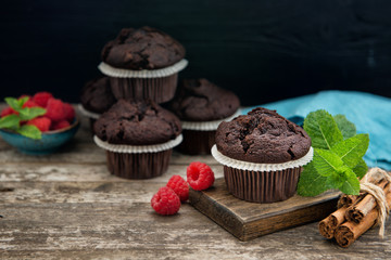 Chocolate muffins with mint leaves and fresh raspberries on the table
