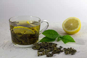 cop of green tea with lemon and leaves on white background