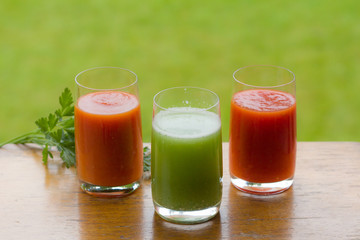 Tomato and cucumber juice on a dark wooden background. Healthy nutrition. Vegetarianism.