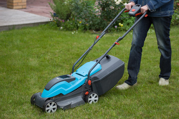 farmer mows grass with a lawn mower. Garden care