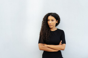 Thoughtful young woman standing staring