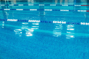 Empty lanes in a swimming pool.Indoor big blue swimming pool interior in modern minimalism style.Lanes of a competition. Healthy life, active sport