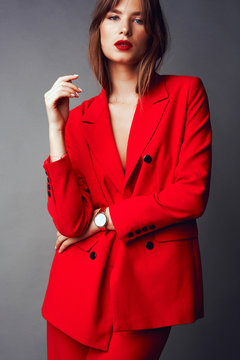 Young Woman In Red Suit. Grey Background